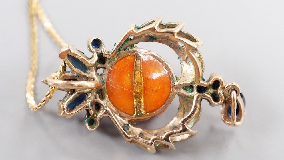 A 20th century yellow metal, carved coral, sapphire and gen set drop pendant, 32mm, on a later 750 chain, 38cm, gross weight 7.9 grams.